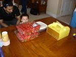 Dung's son Andrew, peeking over some strawberries, as Chirag looks on